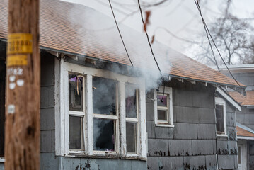 smoke exits out of a window after a house fire