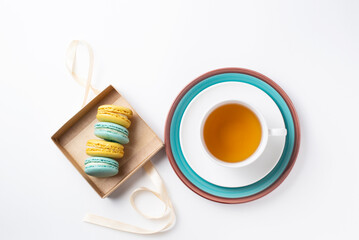 yellow and green macaroons on a light background with tea
