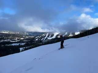Scenic view of a snowboarder on the slopes of Big Sky Ski resort in Montana on a sunny winter day