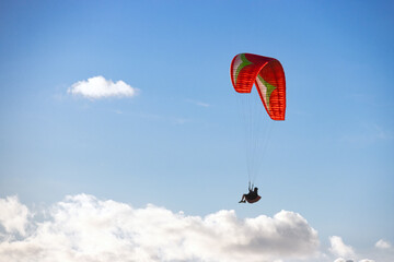 parapentista volando entre las nubes en su parapente