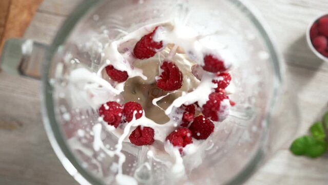 Raspberry and Milk Shake Mixed in Blender in Slow Motion - Top View, Camera Moves Out