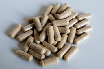 Capsules of brown color close-up on a light background.