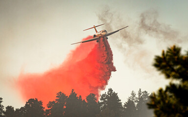 A large air tanker drops red fire retardant on an Oregon wildfire - obrazy, fototapety, plakaty