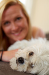 Pet therapy. A woman bonding with her Maltese poodle.