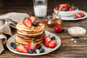 Pancakes with berries and honey. Delicious weekend breakfast	