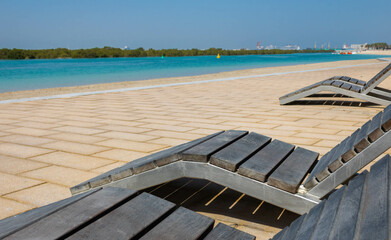 Wooden deck chairs on the promenade by the sea on Reem Island in Abu Dhabi