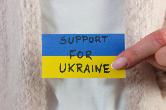 Woman holding Ukrainian flag with text support for Ukraine