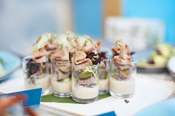 Delicious snacks with olives and meat in glass cups on the banquet table for a buffet. Delicacies close-up, appetizer, antipasti