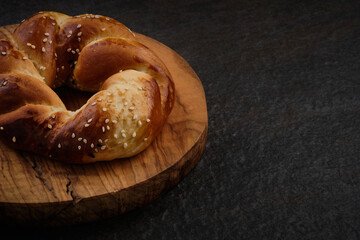 Traditional turkish acma pastry served on wooden board at stone tabletop. Turkish bagel low key with copy space