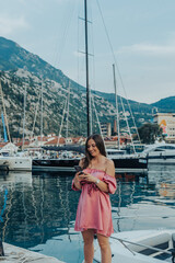 Beautiful young woman using smartphone while walking through the port