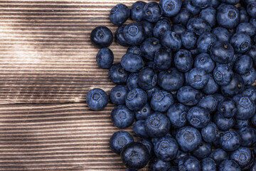 Blueberry background. Ripe blueberry on wooden background.