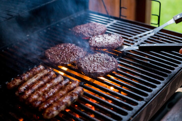 Smoky hamburger meat grilling for burgers. Fry on an open fire on the grill - bbq.Burgers and...