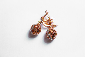 earrings of gold color with a large stone on a white background