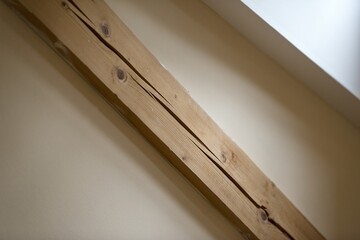 wooden supporting beams of the roof. Detail of wood in interior in background with white wall