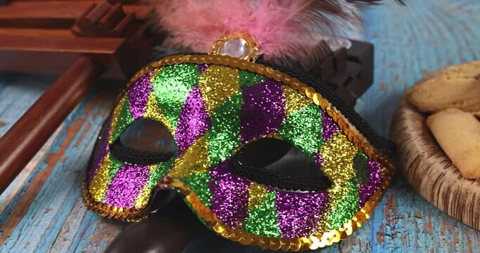 Jewish carnival Purim celebration on hamantaschen cookies, noisemaker and mask with parchment Top view from above.