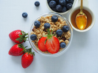 Colorful Healthy diet breakfast with homemade granola muesli and fresh strawberries, blueberries on a white background. The concept of health and beauty. Copy Space for information, top view, Flat Lay
