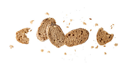 Slices of fresh baked multi grain baguette with poppy, sunflower, sesame seeds flying isolated on...