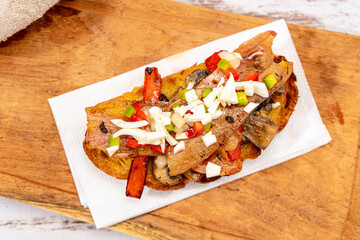 Top view of a rustic bread brusquette with mayonnaise, bacon, mushrooms and vinaigrette, drizzled with olive oil. Typical Spanish tapa.