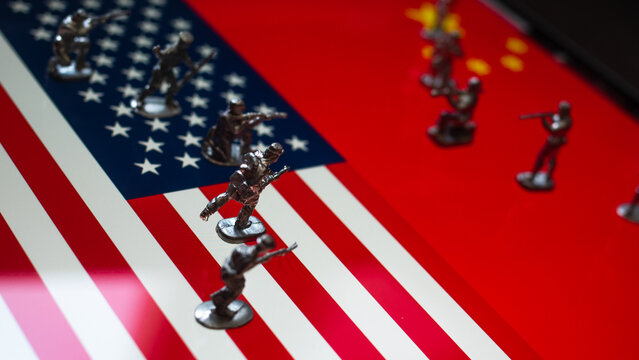 The concept of the economic and political crisis between the United States and China, toy soldiers attacking each other against the background of national flags.