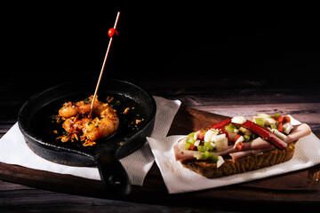 Two different and clasical Spanish tapas on a rustic table with a dark background. traditional spanish cuisine.