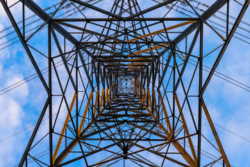 A symmetrical view looking up through the inside of an electricity pylon