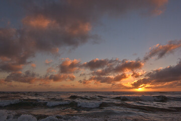playa con olas tranquilas en medio del ocaso o puesta de sol