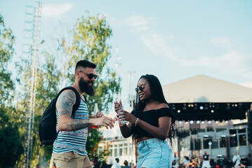 Beautiful couple drinking cocktails and having fun at music festival