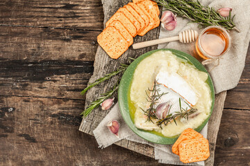 Melted Rougette cheese with fresh rosemary and garlic. Crunchy crackers, honey