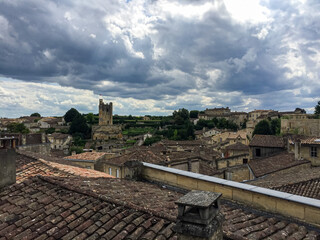 Saint Emilion, Bordeaux, France. Panoramic view of medieval town. Saint Emilion. Panorama view of the medieval town. Limestone houses with shutters and tile rooftop. Tour du Roy tower on a background