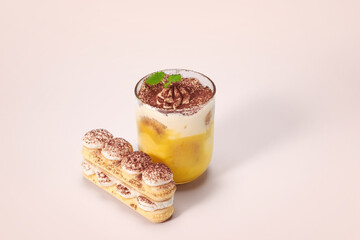 Traditional Italian dessert tiramisu in a glass on brown background