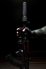 Silenced Kalashnikov assault rifle closeup in the hand of the military. Male hand hold a...