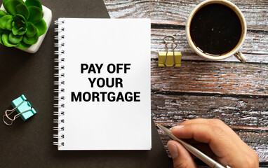 Closeup on businessman holding a card with PAY OFF YOUR MORTGAGE message, business concept image.