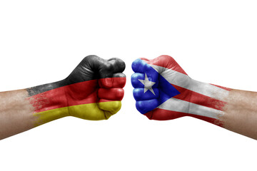 Two hands punch to each others on white background. Country flags painted fists, conflict crisis concept between germany and puerto rico