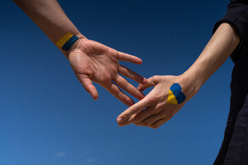 female hands painted in Ukraine flag colors yellow-blue. Stop the war and the power of Ukraine,...