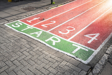 Running tracks painted on the surface of a cobbled street. New start concept.