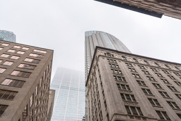 Low angle view of high rise office building shrouded in fog in a financial district. toronto, ON,...