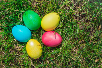 Top view of a bunch of colorful Easter eggs laid out on the green spring grass. Flat style, Easter holiday concept.