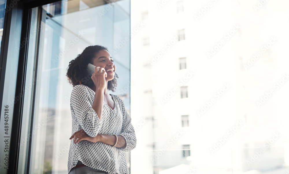 Poster Shes established great connections with her clients. Shot of a young businesswoman talking on a cellphone in an office.