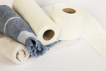 Clean face towels rolled up with paper towels on a white background