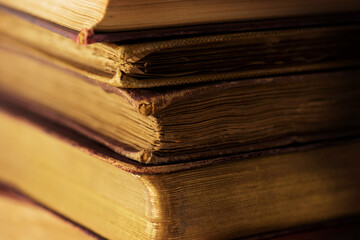 Very old books in light and shadow. Knowledge, wisdom, history concept. Shallow depth of field.