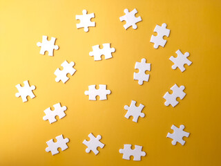 Naklejka premium Top view blank white puzzle on a yellow background.