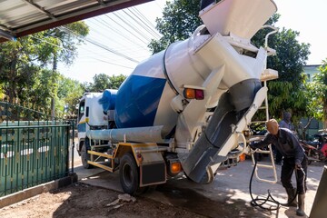 Workers pouring concrete with a cement mixer truck.