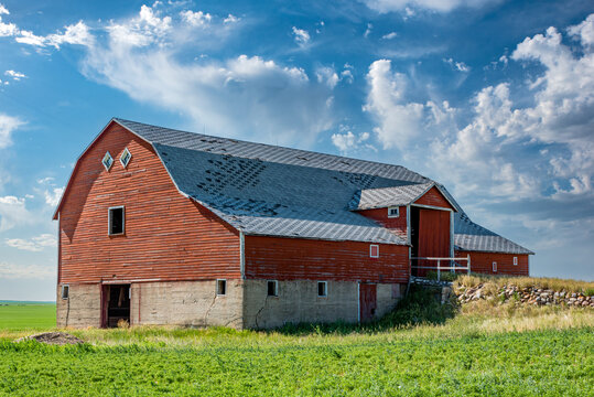 An abandoned red basement or bank barn on the prairies in Saskatchewan 