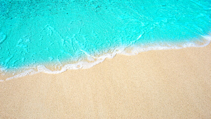 Summer beach background / sea wave on the sand for a space for you to enter text.