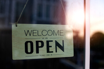 wooden door sign with the text "open" and the idea of â€‹â€‹opening a small business activity again after the incident of Covid-19 ended the lock and went through a crisis.