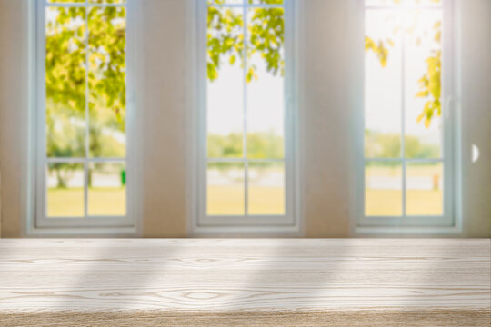 Fototapeta Blurred wood tables in the kitchen on the window background in the morning autumn foliage  for editing in your product