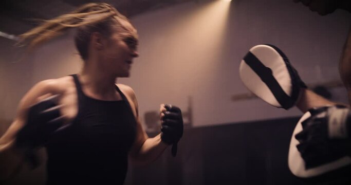 A Strong Man And Woman Sparring / Training In A Martial Arts Gym. Shot In A Crossfit Boxing Gym With Low Key Lighting And A Scattering Of Haze. Captured On Red Digital Cinema Camera 