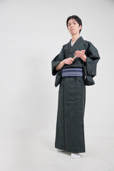 Obraz na płótnie Canvas 扇子を持って手に当てる着物を着た日本人男性