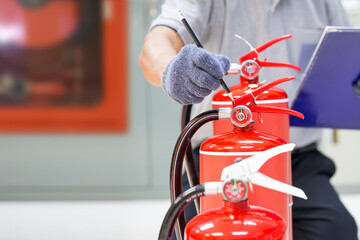 Fire extinguisher has hand engineer inspection checking pressure gauges to prepare fire equipment...