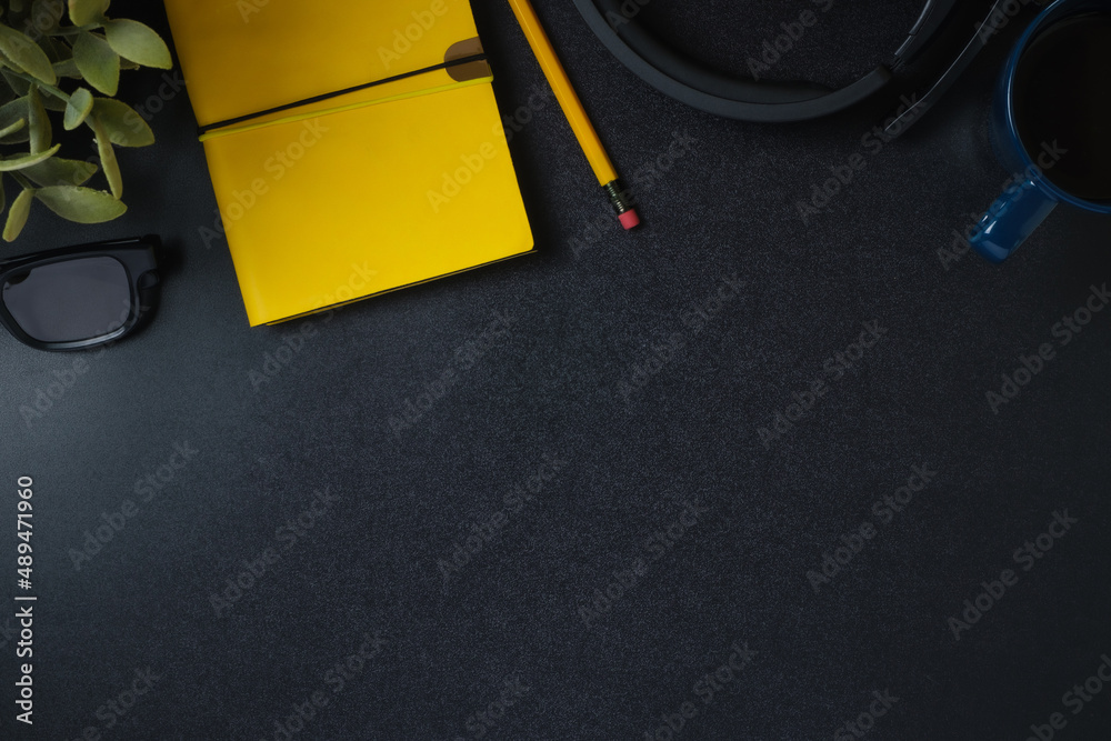 Poster top view working desk notebook,headphone and coffee cup on black table background